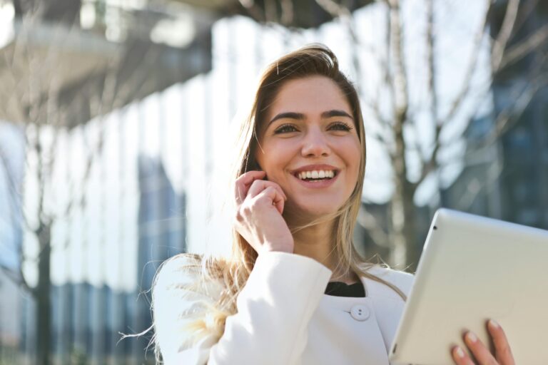 Cheerful professional with tablet and phone supporting Komar Distribution services.