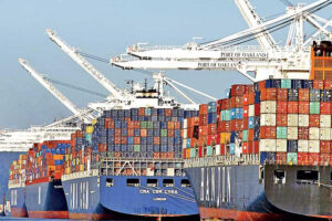 Cargo ships with containers at the Port of Oakland for Komar Distribution